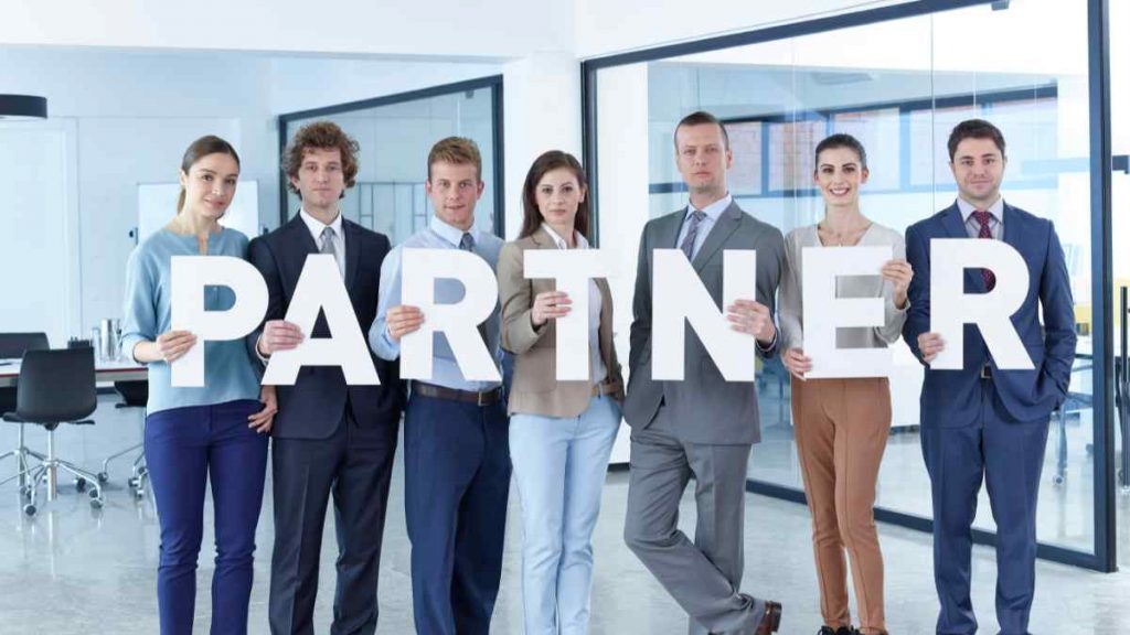 Business team holding 'PARTNER' letters, symbolising working with a digital marketing consultant or strategist