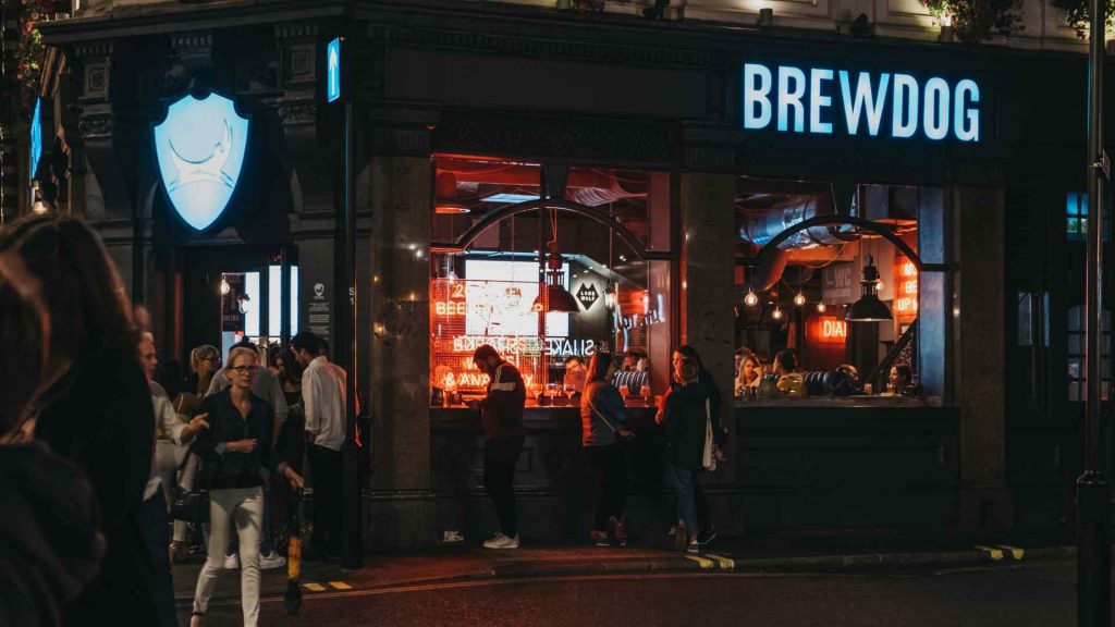 BrewDog bar exterior with crowd at night – market segmentation example of a brand targeting young, rebellious urban drinkers.