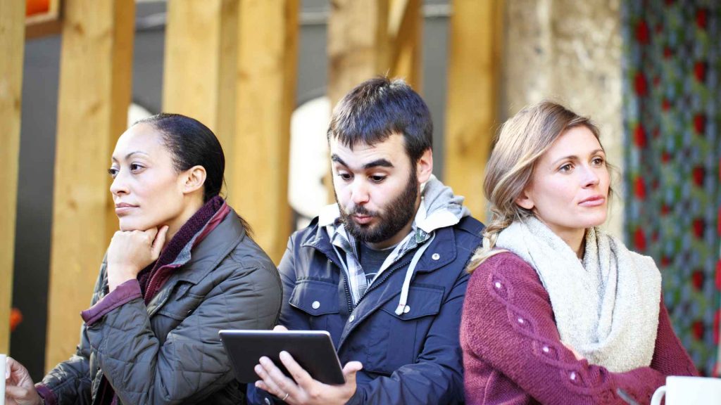 Three people sitting side by side, each with a different expression, representing diverse customer profiles in market segmentation.