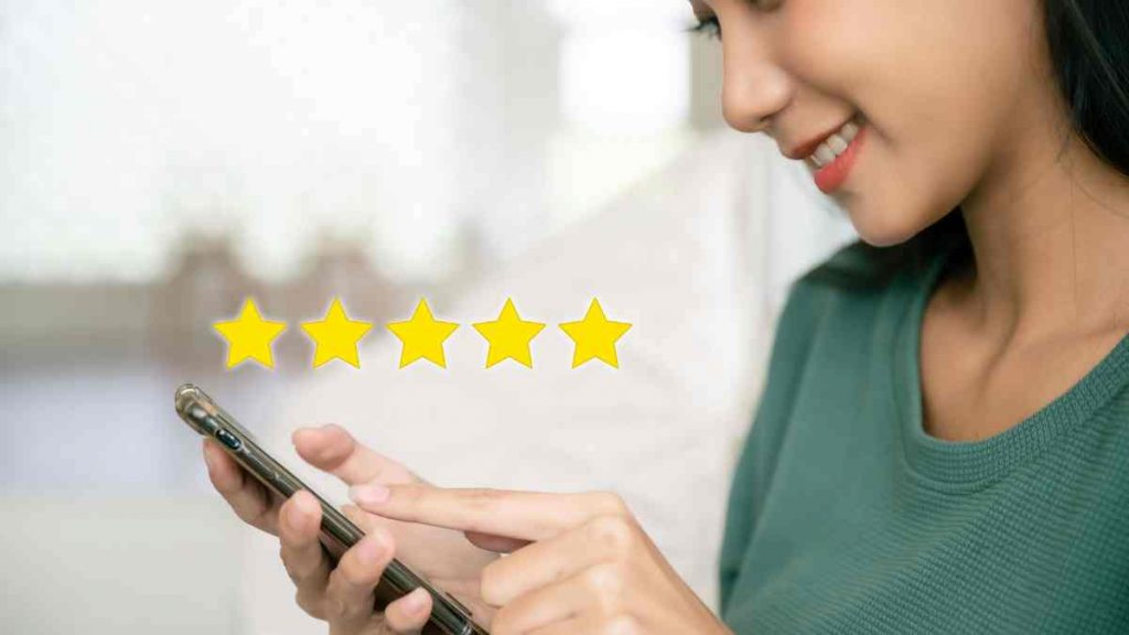 Small business owner reading five-star reviews on mobile phone while evaluating potential digital marketing partner options